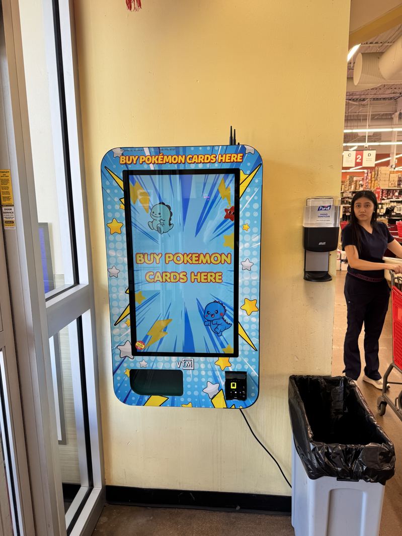 Blue wall-mounted kiosk beside a store entrance door