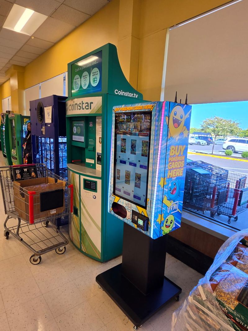 Floor kiosk beside a coin machine at a supermarket entrance